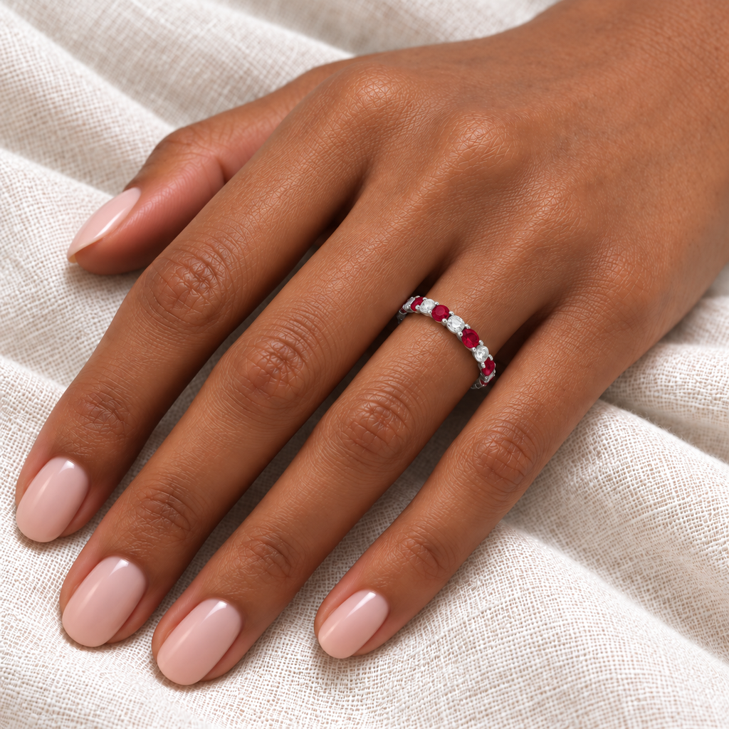 Ruby and diamond eternity ring on hand, ivory linen close-up