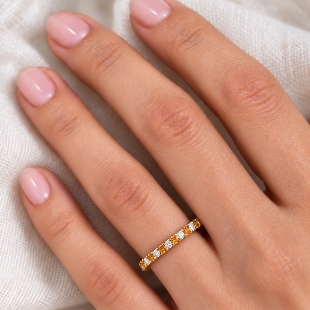 Lab citrine and lab diamond eternity ring in 14k yellow gold, fine-scale ivory-linen hand close-up