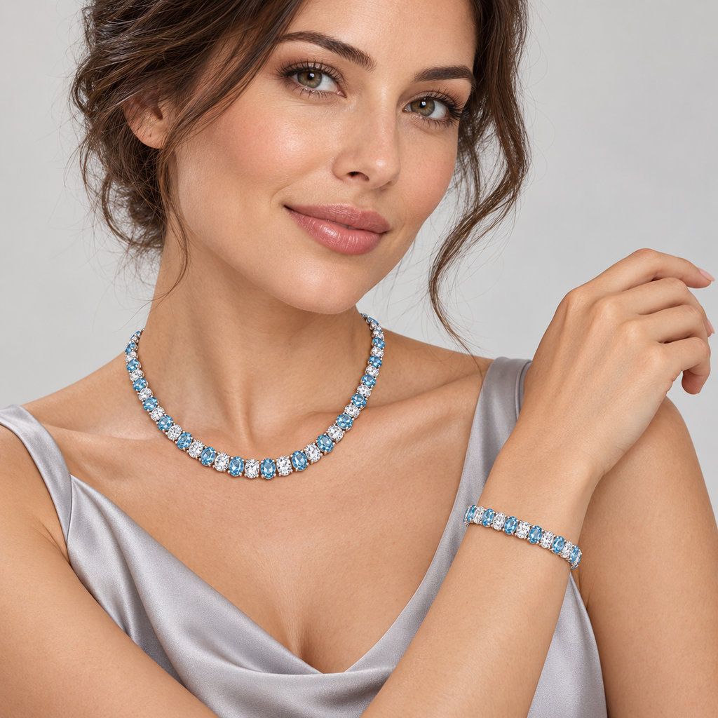 Model wearing the 5 × 3.5 mm oval aquamarine and diamond tennis bracelet with matching graduated necklace in 14k white gold