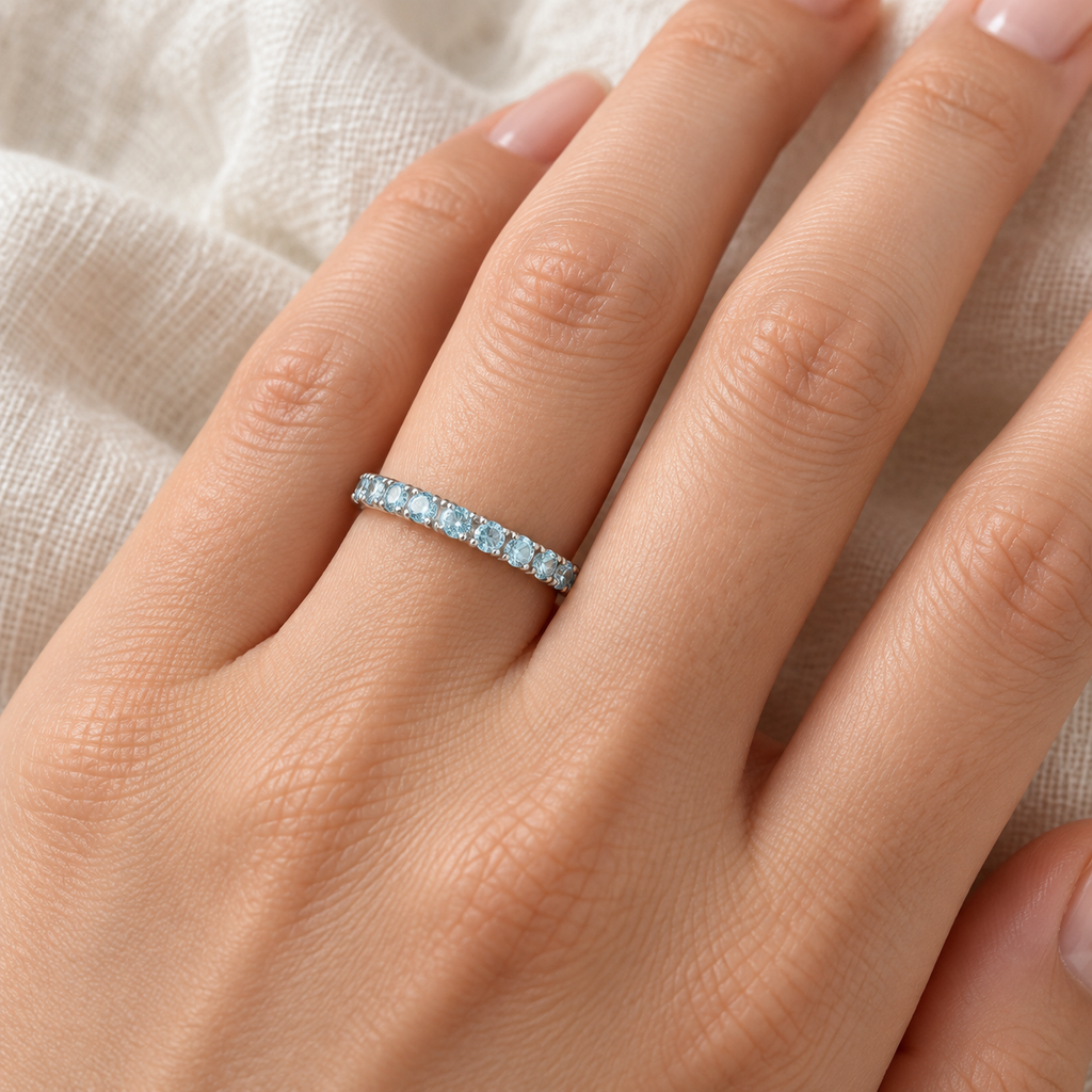 Aquamarine stackable ring in 14k white gold, close-up hand view on ivory linen