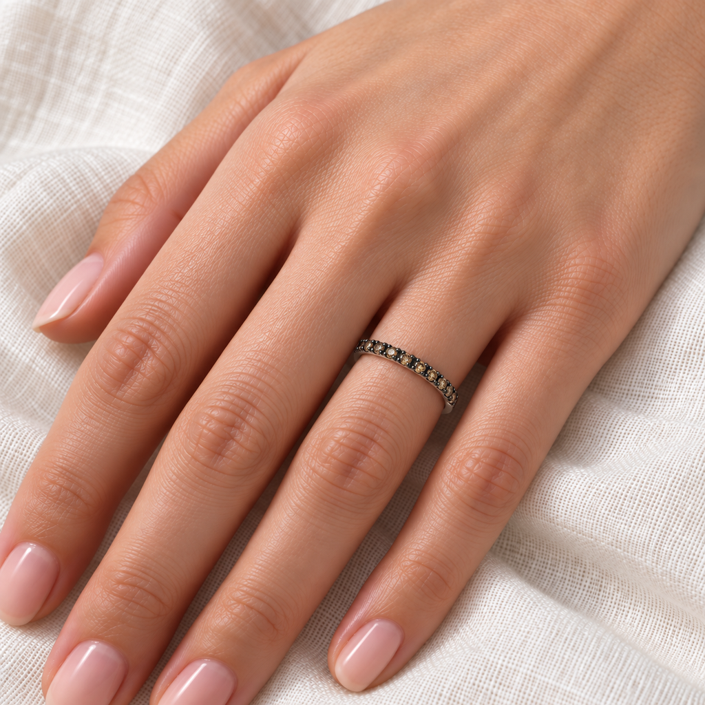 Champagne diamond stackable ring on left hand over ivory linen