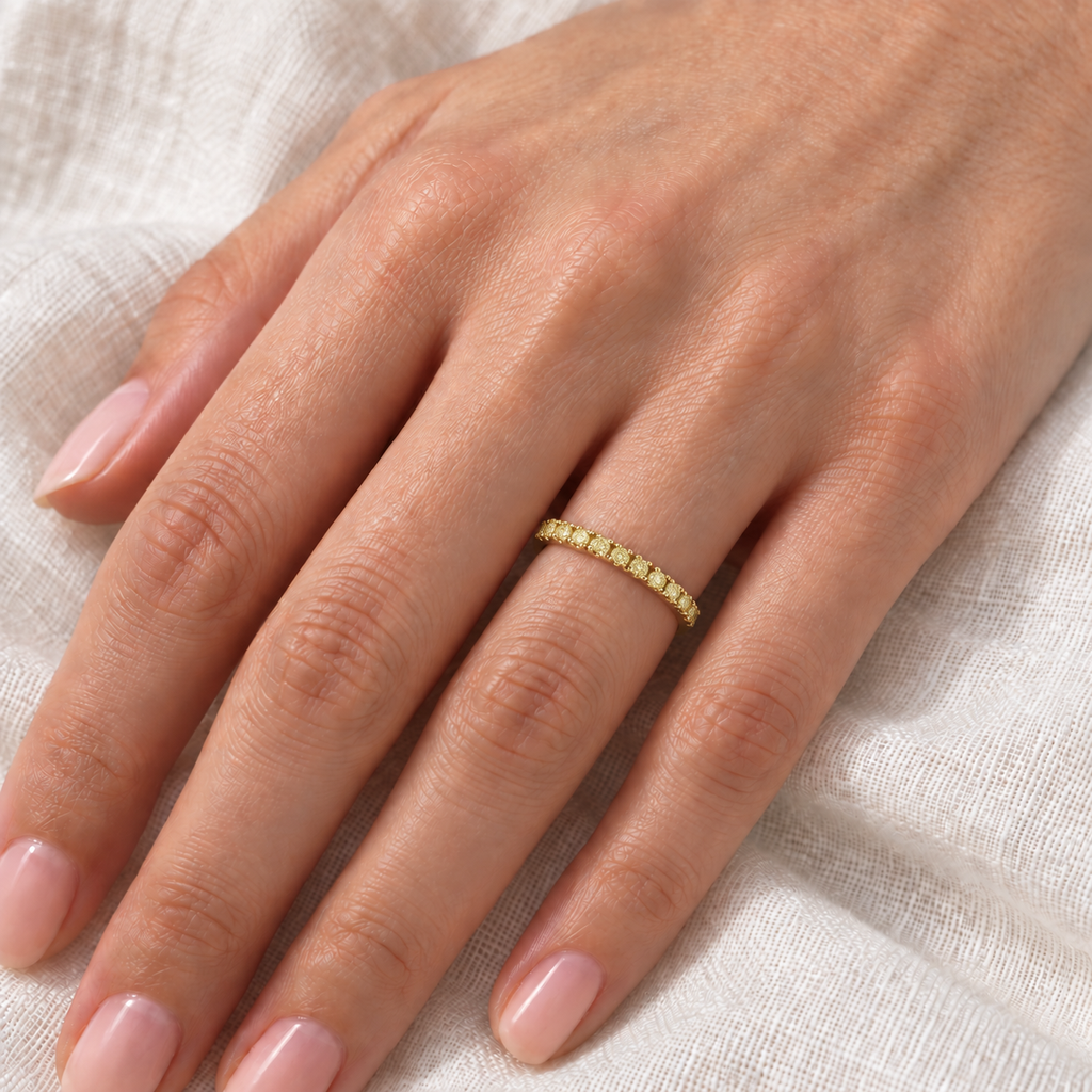 Yellow canary diamond ring on left hand over ivory linen