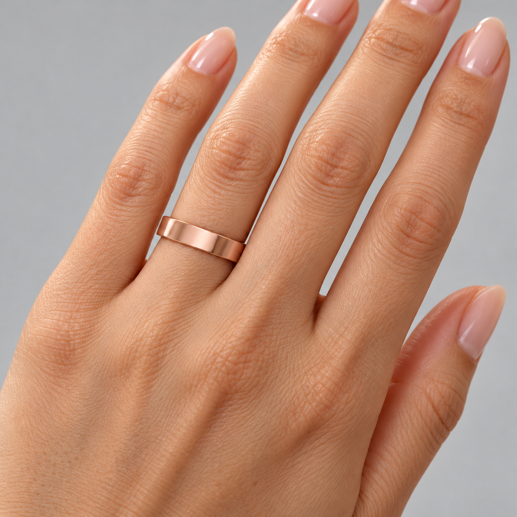 4mm 14K rose gold flat comfort-fit wedding band — female ring-finger studio close-up