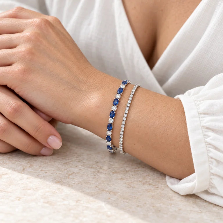 Model wearing a delicate sapphire bracelet beside an all-diamond tennis bracelet